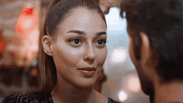a close up of a woman 's face looking at a man 's face