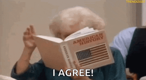 an elderly woman is holding a book in front of her face and says `` i agree '' .