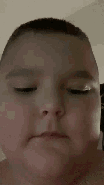 a baby without a shirt is making a funny face with his mouth open