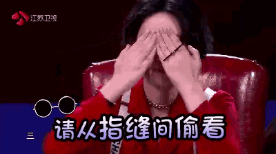 a woman wearing glasses is covering her eyes with her hands in a foreign language