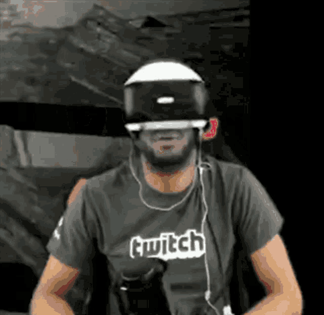 a man is wearing a virtual reality headset and a twitch shirt