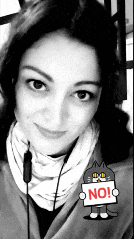 a black and white photo of a woman holding a no sign