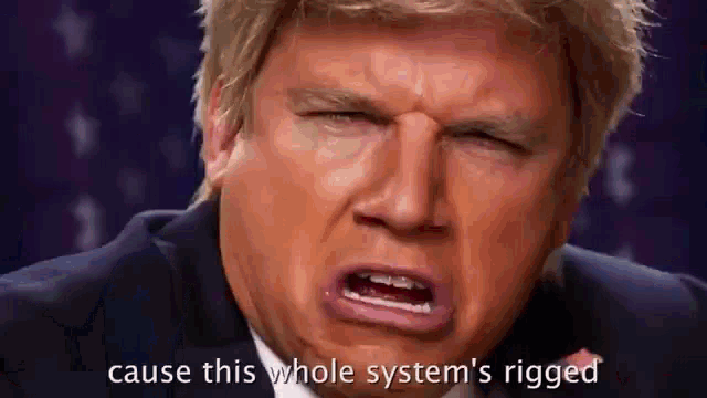 a man in a suit and tie is making a funny face and saying `` cause this whole system 's rigged ''