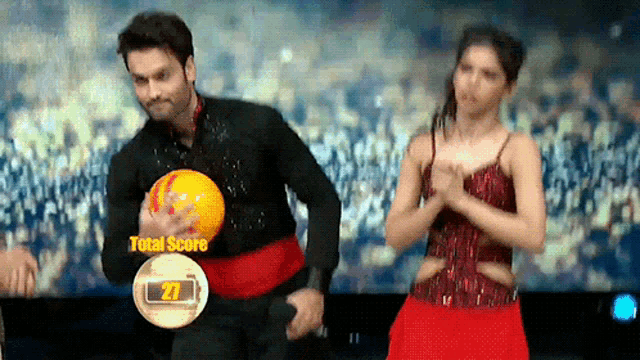a man holding a bowling ball next to a woman who has a total score of 27