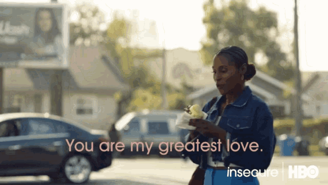 a woman in a denim jacket is holding a plate of food with the words " you are my greatest love " above her