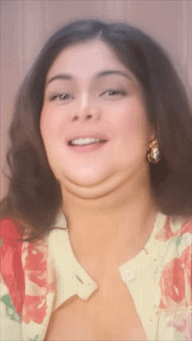 a close up of a woman 's face with a floral shirt
