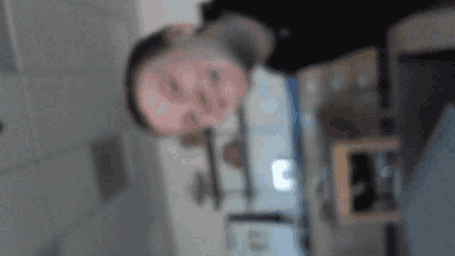 a blurry picture of a man 's face with the letter c on the bottom left