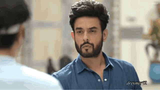 a man with a beard is looking at another man 's face