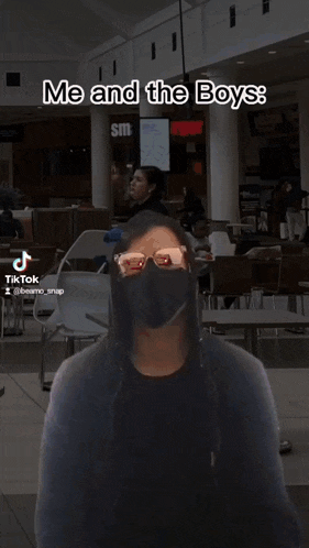 a man in a suit and tie is wearing a mask while dancing with a woman in a hijab behind him ..