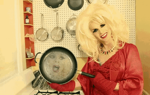 a woman in a red dress holds a frying pan with a face on it
