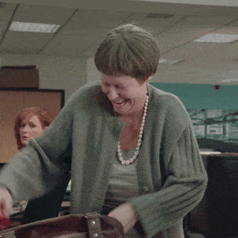 a woman in a grey sweater is holding a red thong