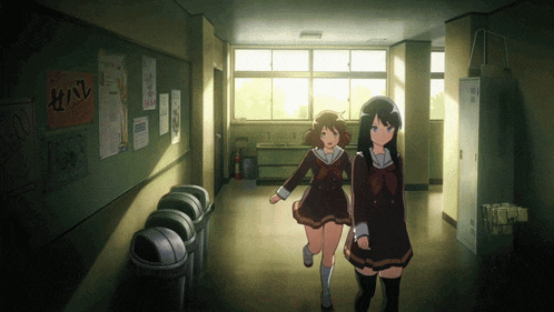 two girls are walking down a hallway with a sign on the wall that says ' i love you '