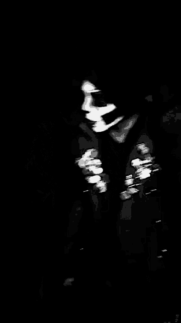 a black and white photo of a man wearing a skeleton mask and gloves