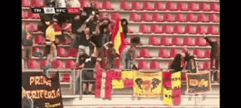 a group of people in a stadium with a sign that says prima