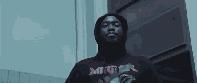 a man is wearing a hoodie that says mirr