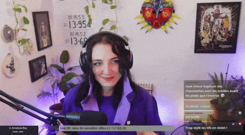 a woman wearing headphones and a purple shirt stands in front of a microphone in front of a sign that says 13954