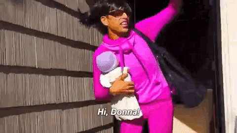 a woman in a purple outfit is holding a baby and says hi donna