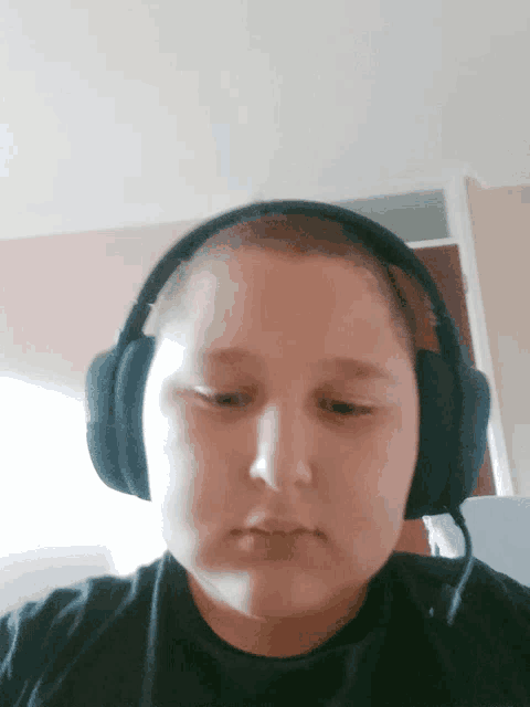 a young boy wearing headphones is making a funny face