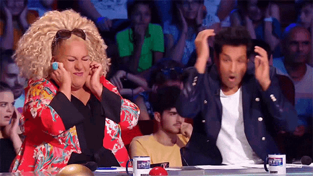 a man and a woman are sitting in front of a crowd and one of the cups has the word talent on it ..