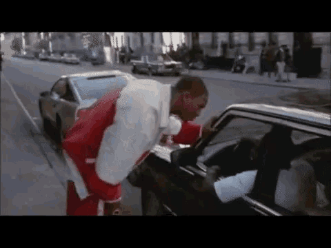 a man in a santa suit is leaning on a car door