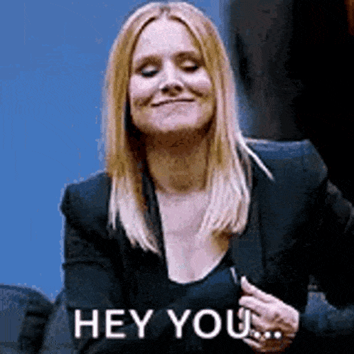 a woman in a black jacket is smiling and saying `` hey you `` .