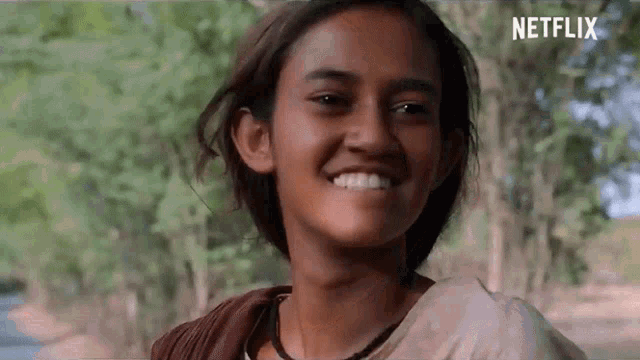 a young girl is smiling and looking at the camera in a netflix trailer .