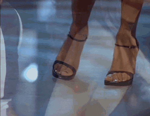 a close up of a woman 's legs wearing black heels