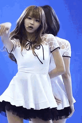 a girl in a white dress with a bow on the neck