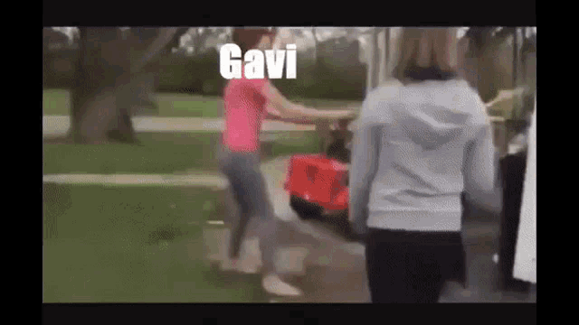 two women standing next to each other with gavi written on the bottom of the screen