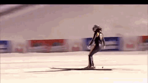 a person is skiing down a snow covered slope with a sign in the background that says coca cola