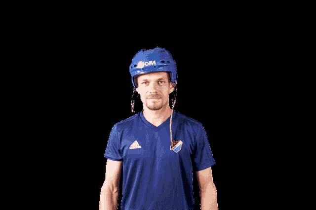 a man wearing a blue adidas shirt and a blue helmet with the word ofa on it