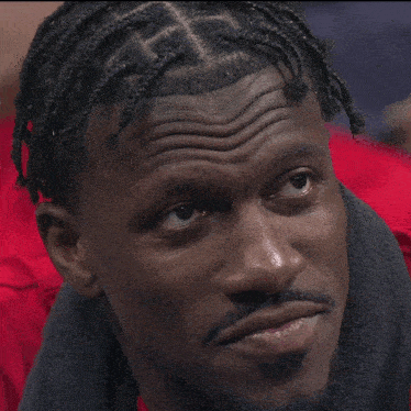 a close up of a man 's face with braids