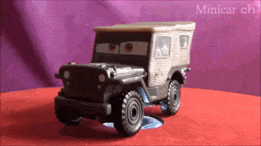 a toy jeep is sitting on top of a red table
