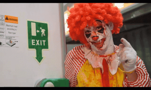 a clown is pointing at a sign that says exit