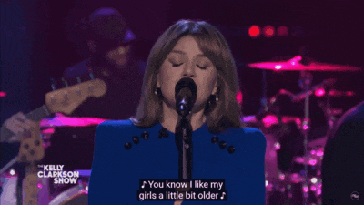 a woman singing on the kelly clarkson show with a purple background