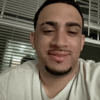 a man with a beard is wearing a white shirt and smiling
