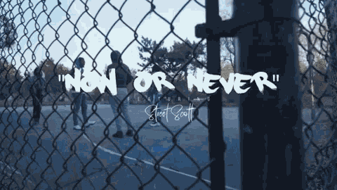 a chain link fence with the words " now or never " written on it