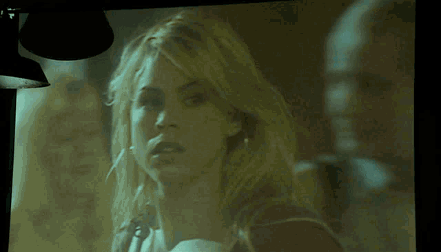 a woman 's face is projected on a large screen