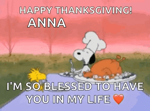 snoopy is sitting at a table with a plate of food and a turkey .
