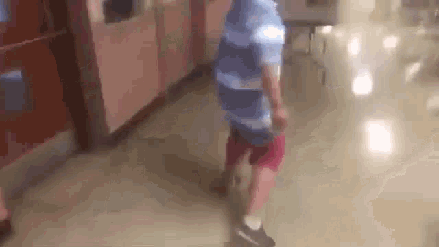 a young boy is walking down a hallway in a hospital .