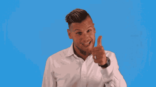 a man in a white shirt giving a thumbs up sign