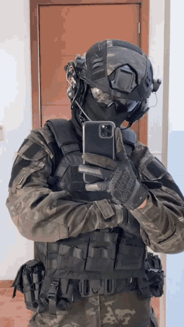 a man in a military uniform takes a selfie with a cell phone