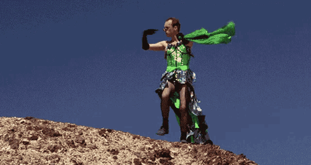 a man in a green dress is holding a green cloth