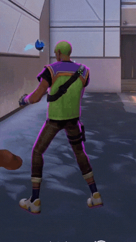 a man in a green vest and purple pants is standing in a hallway