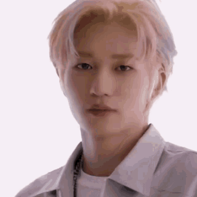 a close up of a young man 's face with pink hair .