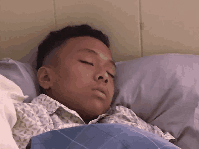 a young boy is sleeping with his eyes closed