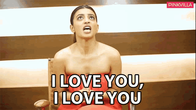 a woman in a red dress is sitting in a chair and saying i love you