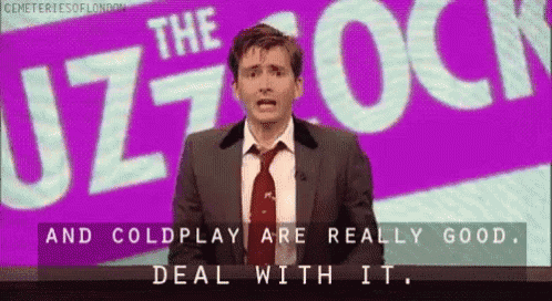 a man in a suit and tie is standing in front of a purple sign that says the uzz rock