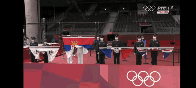 a group of people holding flags in front of a sign that says olympics
