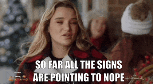a woman says " so far all the signs are pointing to nope " in front of a christmas tree